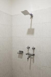 a shower with two faucets in a bathroom at Artllers at Vicctoria House, All Mountain View rooms with Free Parking in McLeod Ganj