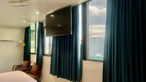 a bedroom with a bed and a window with blue curtains at ĐÔNG NHƯ HOTEL in Ho Chi Minh City +26 photos