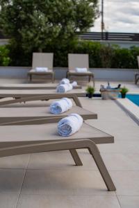 a row of benches with rolled towels on them at Villas Royal III in Novalja