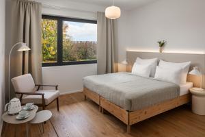 a bedroom with a bed and a chair and a window at Resort po.spolu in Mokrovraty