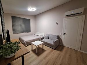 KarmėlavaにあるKambarių nuoma prie Kauno oro uostoのベッドと椅子とテーブルのある部屋