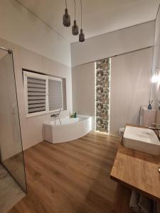 KarmėlavaにあるKambarių nuoma prie Kauno oro uostoの洗面台と浴槽のあるバスルーム +1枚の写真