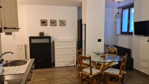 a kitchen and dining room with a table and chairs at Monolocale Sauze d'Oulx in Sauze dʼOulx +3 photos