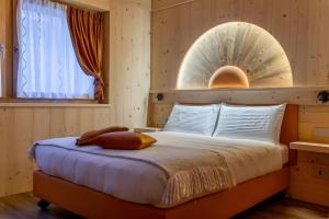 a bedroom with a bed with a mirror on the wall at Chalet Imbosc'chè 5 rooms Bnb in Livigno