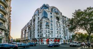 a large white building on a city street with cars at Lux Apartment View Baku Formula 1 Street in Baku