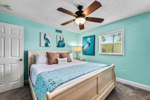 a bedroom with a bed with a ceiling fan at Plumbago - 5251C in Siesta Key +52 photos