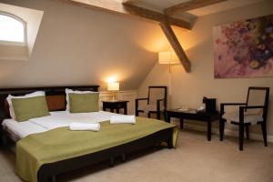 a bedroom with a large bed and two chairs at Hirscher Loft in Braşov