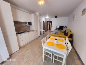 a kitchen and a living room with a white table and chairs at Luxury Seaside Apartment Alezzi Green Swimming Pool in Mamaia Nord +9 photos