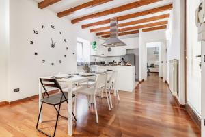 une cuisine et une salle à manger avec une table et des chaises blanches dans l'établissement Soffio del Lago, à Pusiano