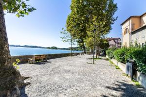 un trottoir à côté d'un lac avec banc dans l'établissement Soffio del Lago, à Pusiano