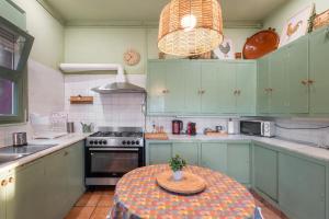 a kitchen with green cabinets and a table with a plant on it at Tordera Village in Tordera