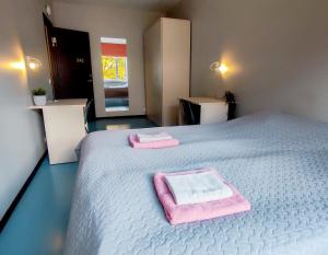 タリンにあるTallinn Airport Stayのベッドとタオル2枚のある寝室
