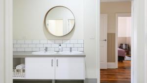 ein weißes Badezimmer mit zwei Waschbecken und einem Spiegel in der Unterkunft Heritage Cottage Daylesford in Daylesford