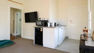 eine Küche mit Mikrowelle und schwarzem Geschirrspüler in der Unterkunft Heritage Cottage Daylesford in Daylesford + 4 Fotos