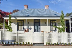 einen weißen Zaun vor einem weißen Haus in der Unterkunft Heritage Cottage Daylesford in Daylesford