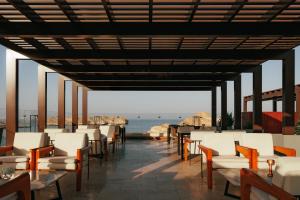 a restaurant with chairs and tables and a view of the ocean at Jumeirah Muscat Bay Oman in Muscat