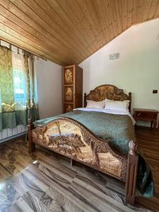 un dormitorio con una cama grande en una habitación en Hanul Vanatorului, en Gureni
