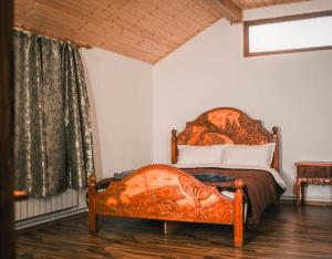 a bedroom with a bed with an orange bedspread at Hanul Vanatorului in Gureni