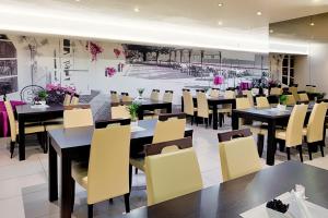 a restaurant with black tables and yellow chairs at Boutique Hotel's II Rewolucji in Łódź
