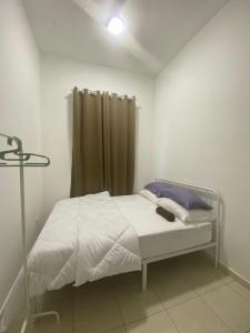 En eller flere senge i et værelse på Loka Homestay Kluang