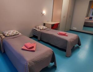 タリンにあるTallinn Airport Stayのベッド2台(赤いタオル付)が備わる客室です。