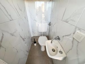 a white bathroom with a toilet and a sink at Robinson Ina 1 in Gdinj +33 photos