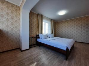 a bedroom with a bed with blue sheets and a window at Двокімнатна квартира з кондиционером документи на відрядження in Poltava