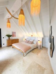 a bedroom with a bed and two chandeliers at SEA NOVA Friar's Bay Beachfront Properties in Saint Martin