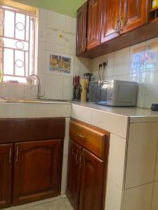 a kitchen with wooden cabinets and a microwave on the counter at Laala Homes in Kampala