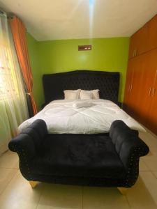 a bedroom with a black bed and a black couch at Laala Homes in Kampala