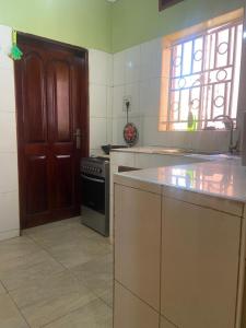 a kitchen with a sink and a stove and a window at Laala Homes in Kampala +3 photos