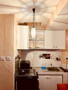 基苏木Cozy Studio-Garden Pool Restaurant, 5 mins to CBD的厨房配有白色橱柜和炉灶烤箱