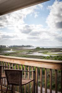 a balcony with a chair and a view of the ocean at Sandy Hook in Galveston
