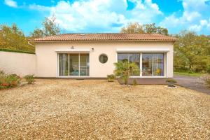 une maison avec une allée de gravier devant elle dans l'établissement Loft piscine chauffée et couverte, à Sauvignac