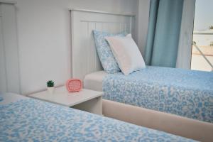 una camera con due letti e un orologio su un tavolo di Casa Min26 a Caleta De Fuste