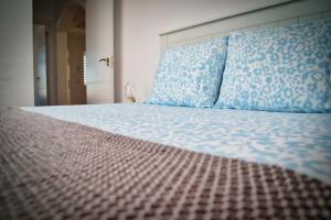 una camera da letto con un letto grande con cuscini blu di Casa Min26 a Caleta De Fuste