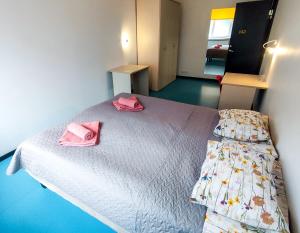 a bedroom with a bed with pink towels on it at Tallinn Airport Stay in Tallinn