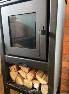 a toaster oven with a pile of wood in it at Via Kairós - Rancho Queimado - SC in Rancho Queimado