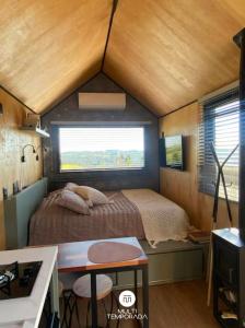a small bedroom with a bed in a tiny house at Via Kairós - Rancho Queimado - SC in Rancho Queimado
