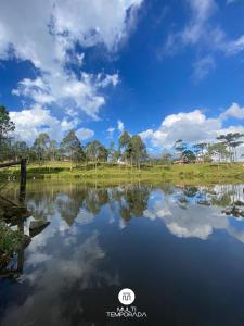 a reflection of the sky in a lake at Via Kairós - Rancho Queimado - SC in Rancho Queimado