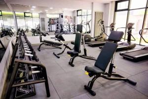 a gym with rows of exercise bikes and treadmills at Luxury Seaside Apartment Alezzi Green Swimming Pool in Mamaia Nord