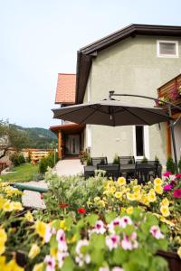 Un patio con una sombrilla y algunas flores. en Zeller Panorama, en Mariazell