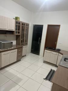 a kitchen with wooden cabinets and a tile floor at Casa refúgio in Ibicoara