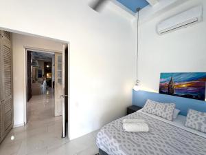 ein Schlafzimmer mit einem Bett und einem Gemälde an der Wand in der Unterkunft Casa Lazuli 303 Cartagena in Cartagena de Indias