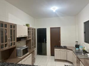 a large kitchen with wooden cabinets and a refrigerator at Casa refúgio in Ibicoara