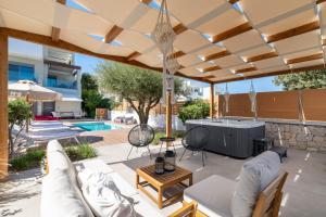 un patio con una sombrilla grande y una piscina en Terpsis Pool Villa, en Rodas 26 fotos más