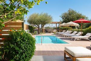 una piscina con tumbonas y sombrillas junto a en Terpsis Pool Villa, en Rodas