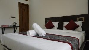 奇克马格尔Shrivari Homestay的卧室里有一张白色的大床，上面有红色的枕头