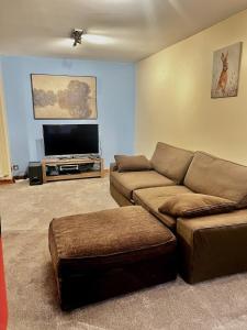 a living room with a couch and a flat screen tv at Dartford Cozy One-Bedroom Flat - Sleeps 2 in Sutton at Hone