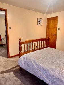a bedroom with a wooden bed and a wooden door at Dartford Cozy One-Bedroom Flat - Sleeps 2 in Sutton at Hone